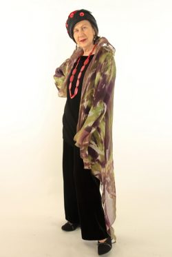 Woman in colorful outfit and hat posing.